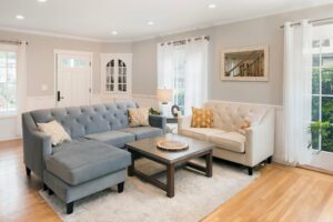 Neutral living room with hardwood floors and large area rug anchoring sectional seating in a comfortable family space
