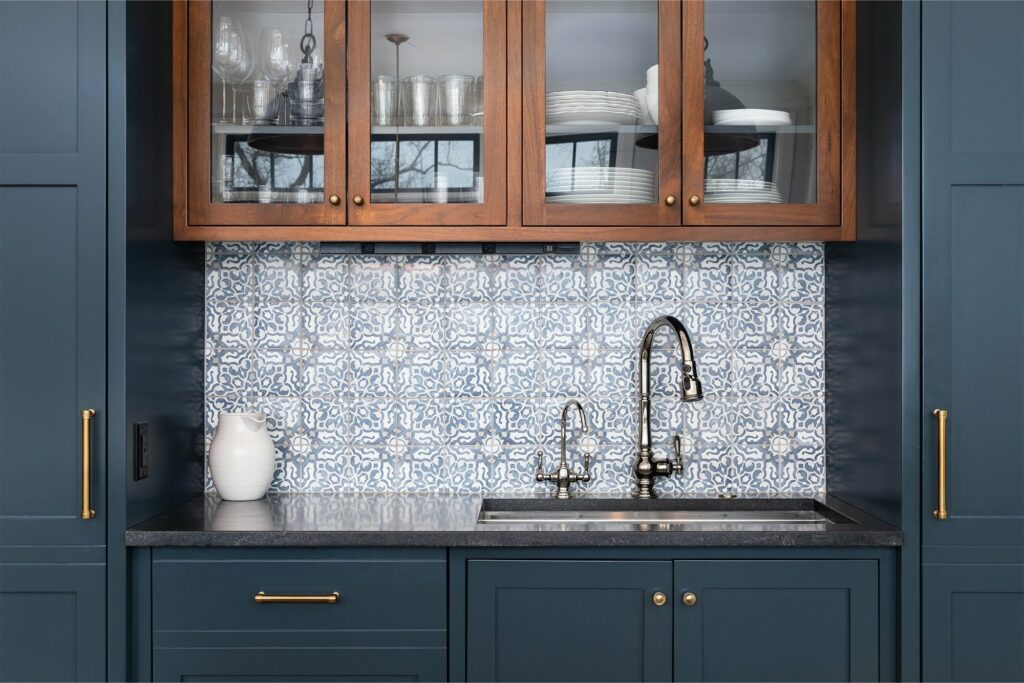 blue painted kitchen cabinets with wood upper cabinets patterned tile backsplash stainless steel faucet custom cabinetry kitchen design