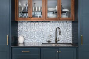 blue painted kitchen cabinets with wood upper cabinets patterned tile backsplash stainless steel faucet custom cabinetry kitchen design