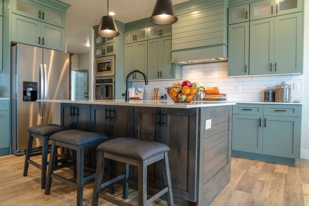 two tone kitchen design with sage green cabinets dark wood island quartz countertops and luxury vinyl plank flooring